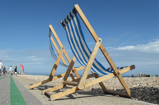 Two blue and white striped deckchairs on the promenade