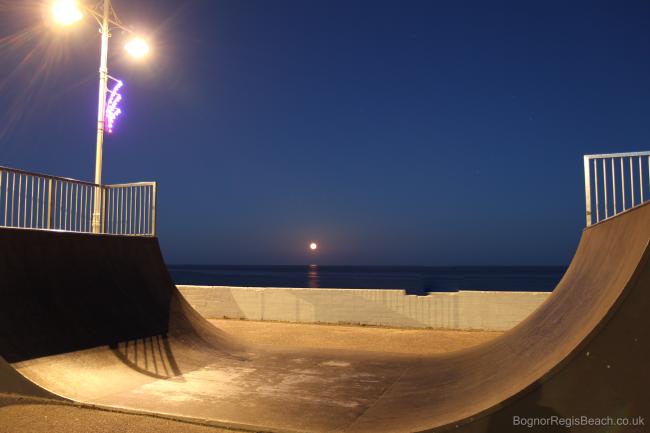 Nightime view of the skate park by the promenade with rising moon
