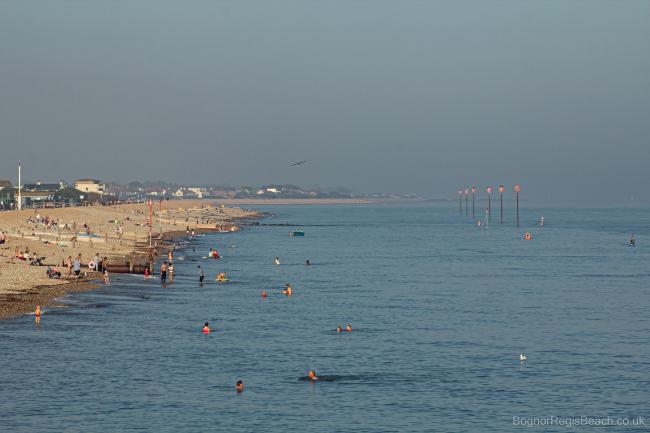 View of east beach from the the pier on a hot day in summer with people